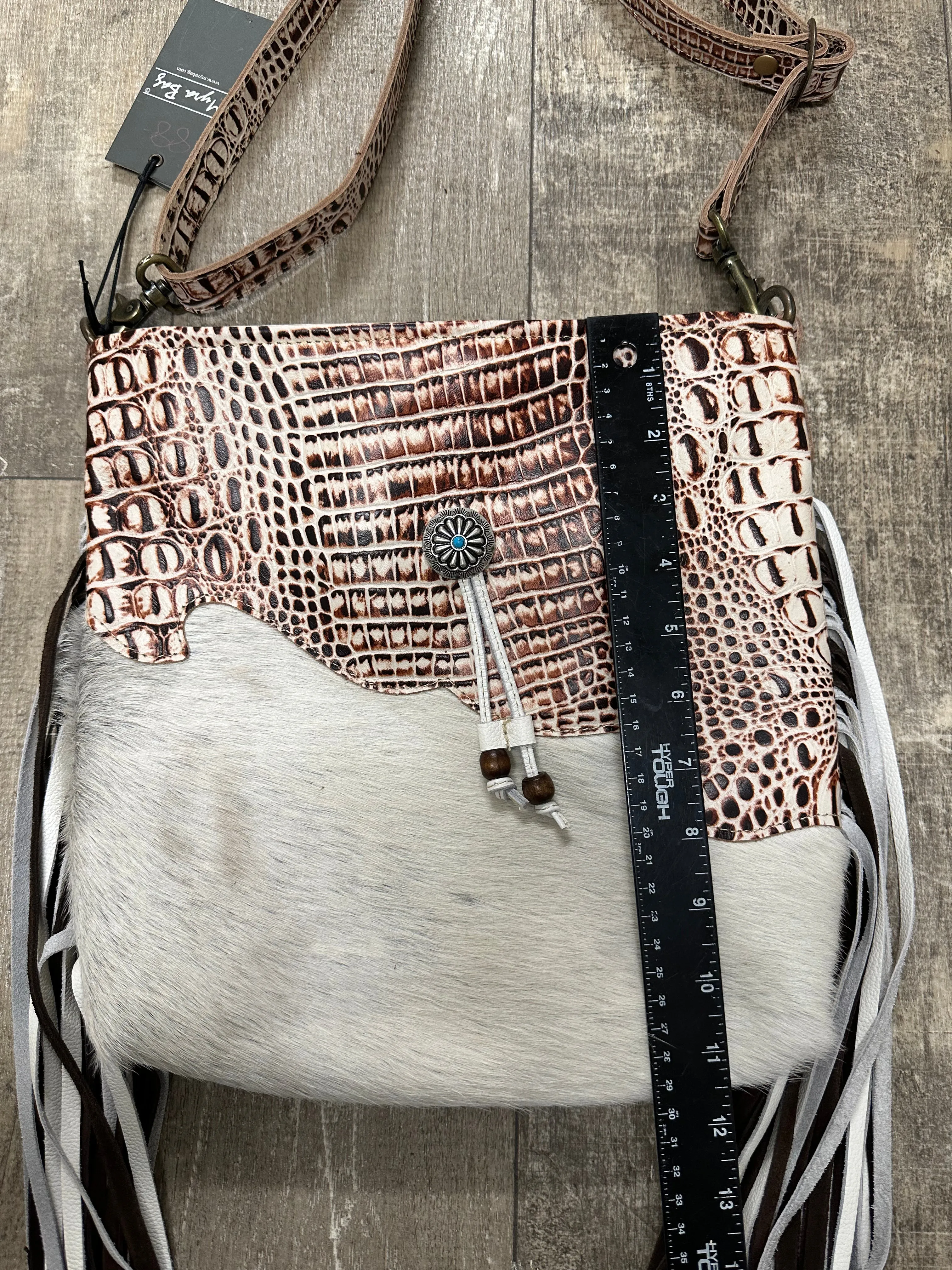 cowhide hand bag with leather strap and fringe